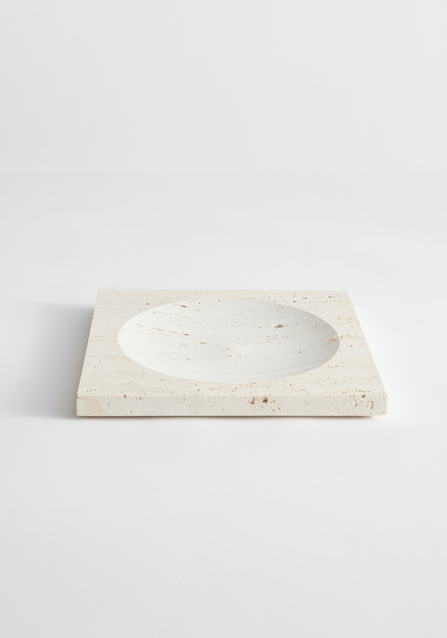 Medium tray | travertine: A square travertine slab with a round indent, handcrafted by Louis Crombag, measuring 26cm x 26cm, showcasing minimalist design.