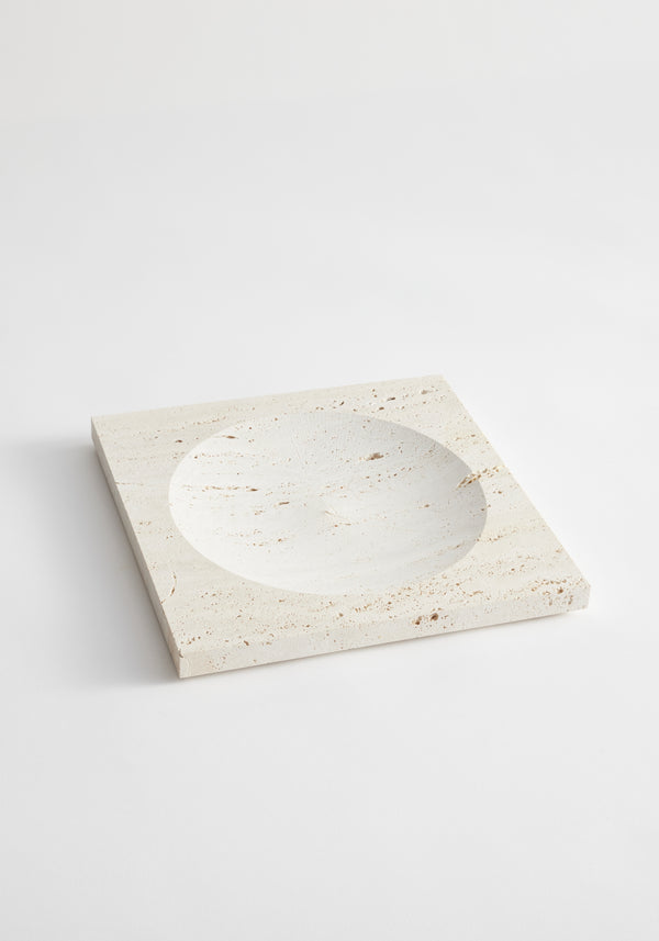 Medium tray | travertine: A handcrafted, light-beige square stone tray with a central round indent, made from leftover Italian travertine by Dutch artist Louis Crombag.