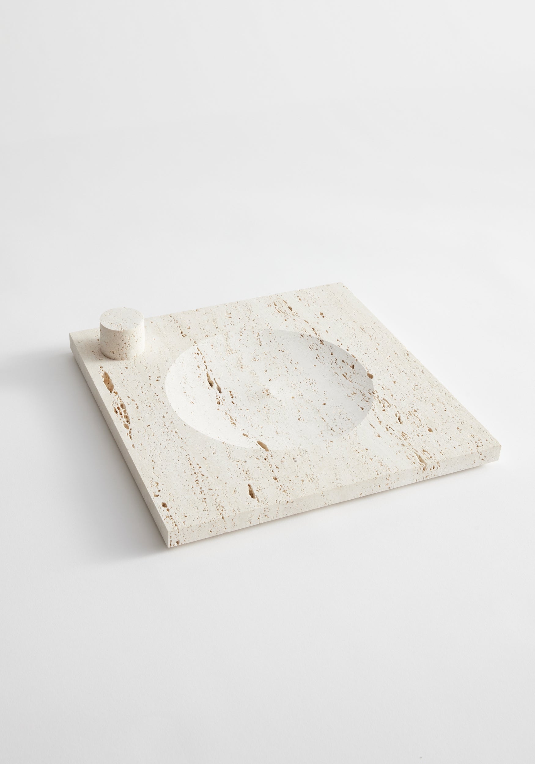Large tray | travertine slab with a central round indent and a small travertine cylinder for candles, handcrafted by Louis Crombag in the Netherlands.