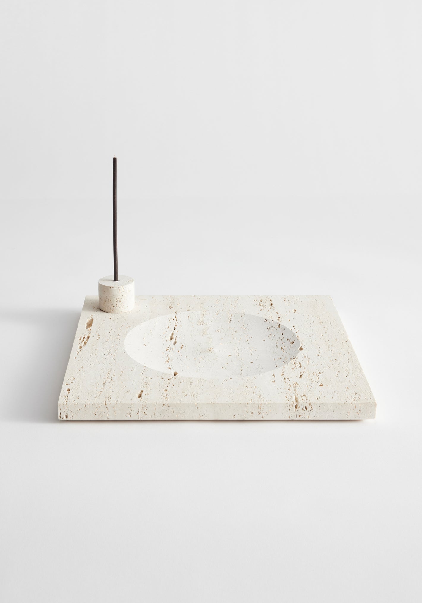 Large tray | travertine: Beige travertine slab with circular indent and incense holder, handcrafted in the Netherlands. Includes two 5mm candles.