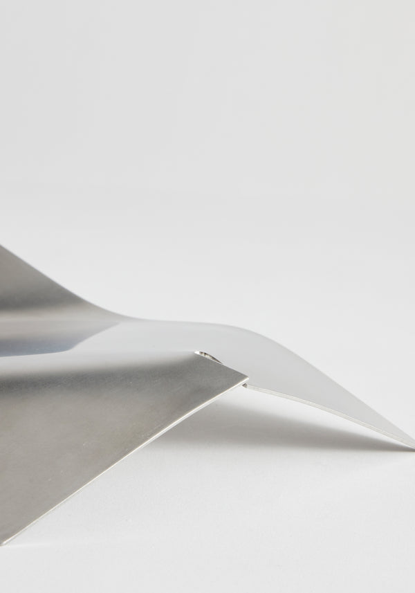 Stainless steel bowl showcasing a minimalist design with sharp bends and polished surfaces, crafted in collaboration with Dutch designer Paul Coenen, handcrafted in the Netherlands.