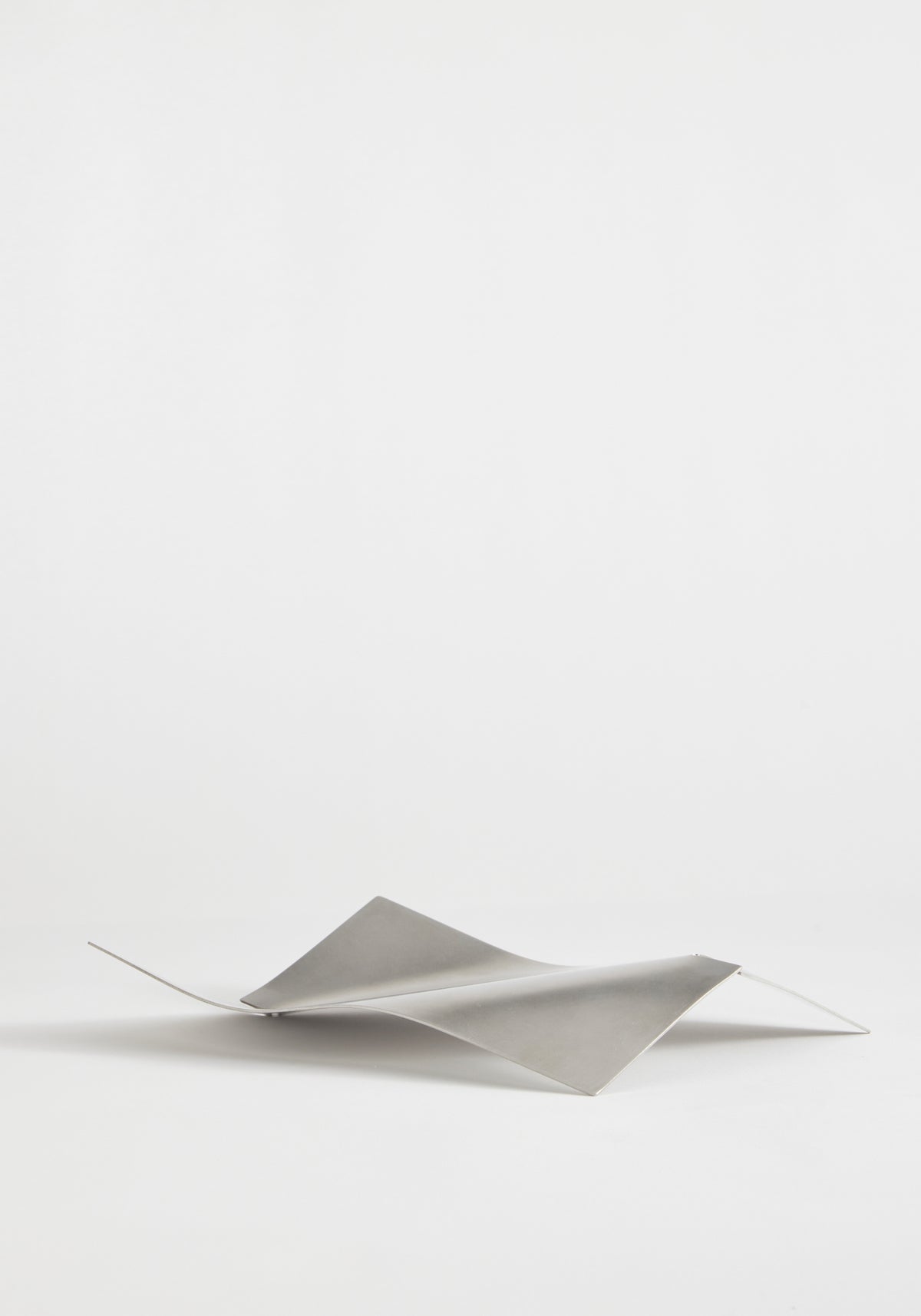 Stainless steel bowl in a saddle-like, minimalist form, crafted from a thin, bent sheet. Collaboration with Dutch designer Paul Coenen, handcrafted in the Netherlands.