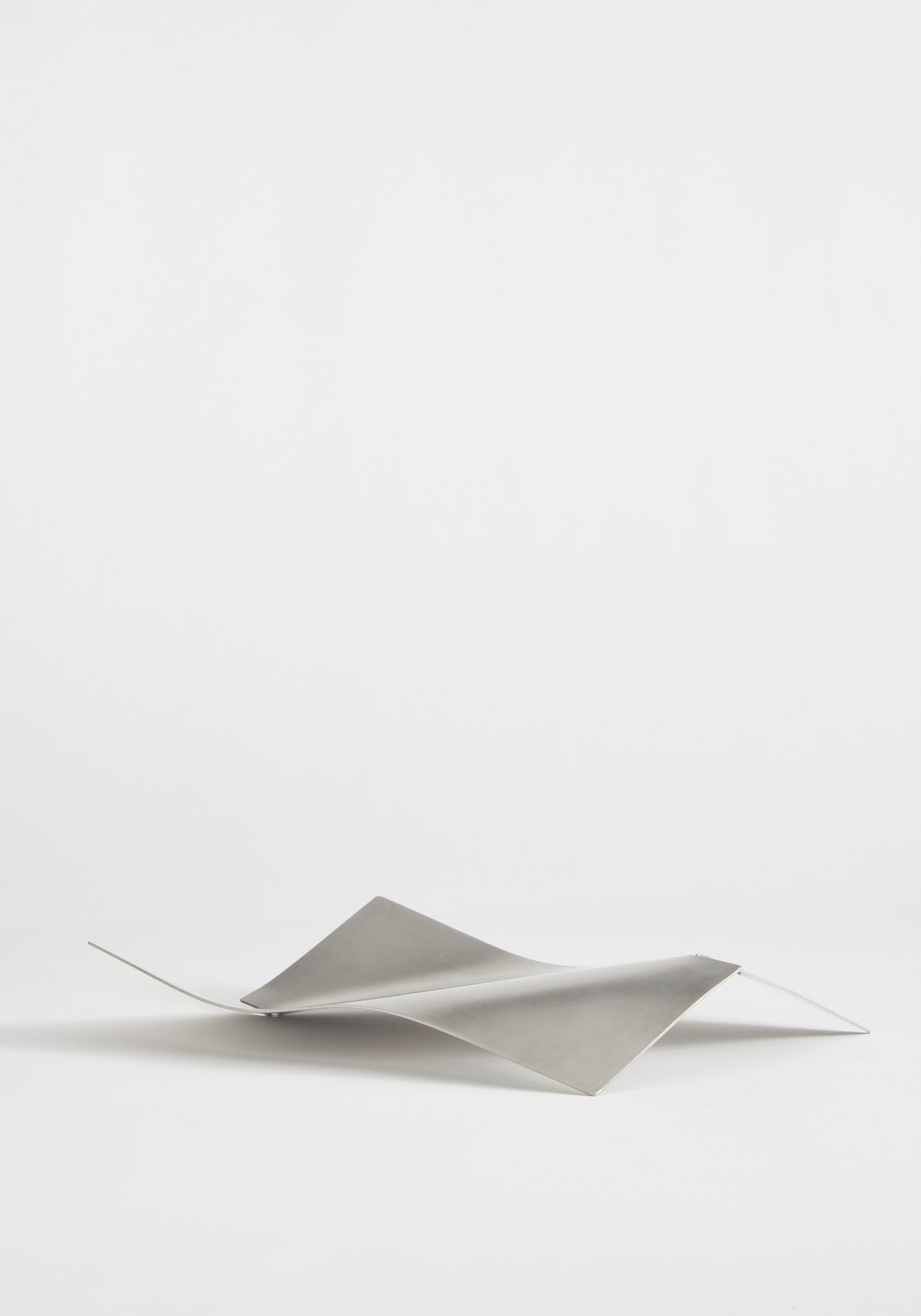 Stainless steel bowl in a saddle-like, minimalist form, crafted from a thin, bent sheet. Collaboration with Dutch designer Paul Coenen, handcrafted in the Netherlands.
