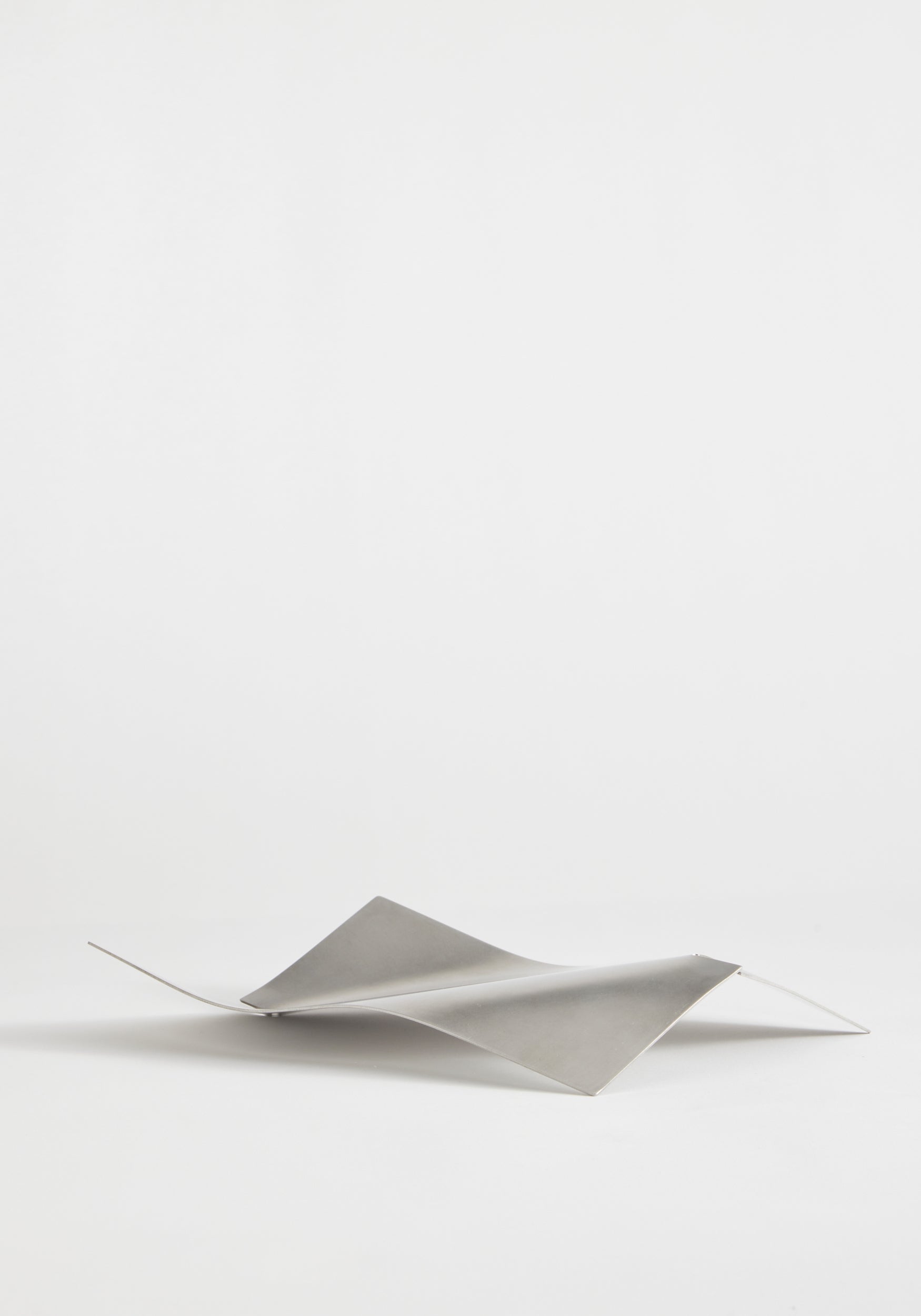 Stainless steel bowl in a saddle-like, minimalist form, crafted from a thin, bent sheet. Collaboration with Dutch designer Paul Coenen, handcrafted in the Netherlands.