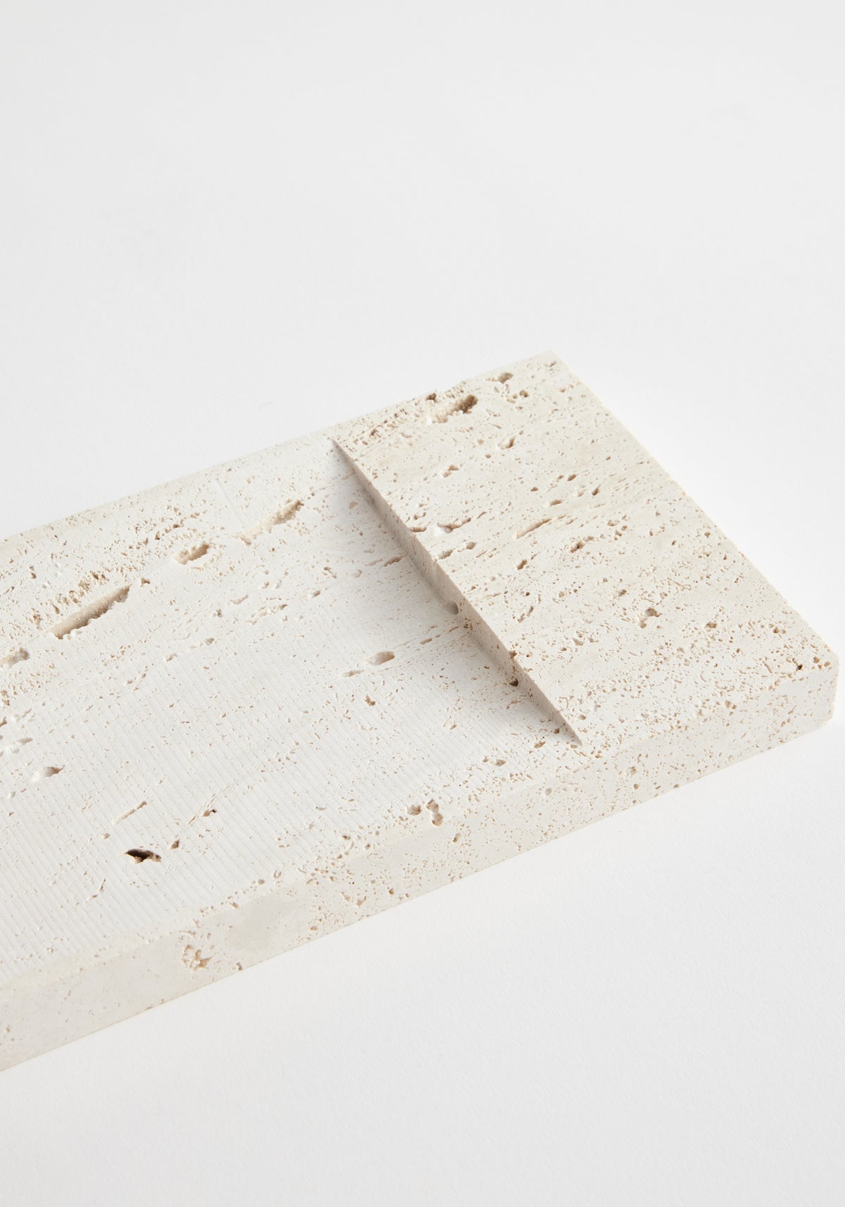Incense holder tray | travertine: Two handcrafted beige travertine slabs, textured and rectangular, with one angled atop the other, showcasing unique, porous surfaces.