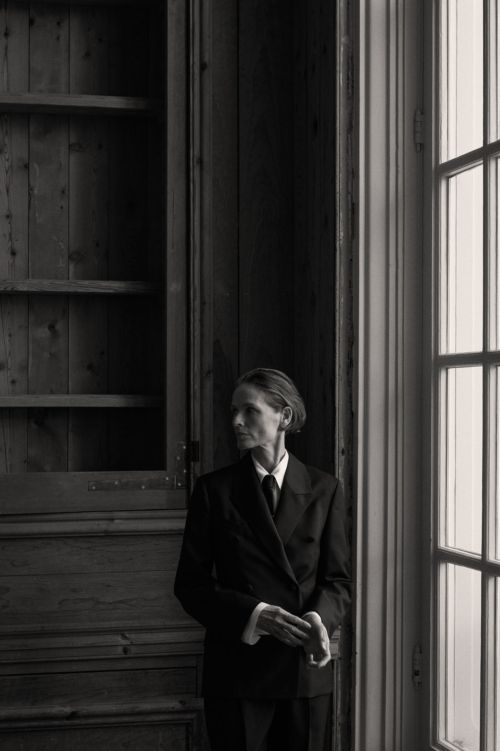 Woman standing in a historic amsterdam building in a classic tailored suit