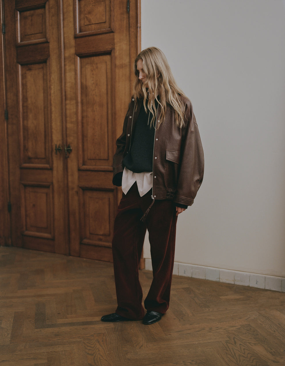 Woman standing in an amsterdam building in a full clothing look from Rohe