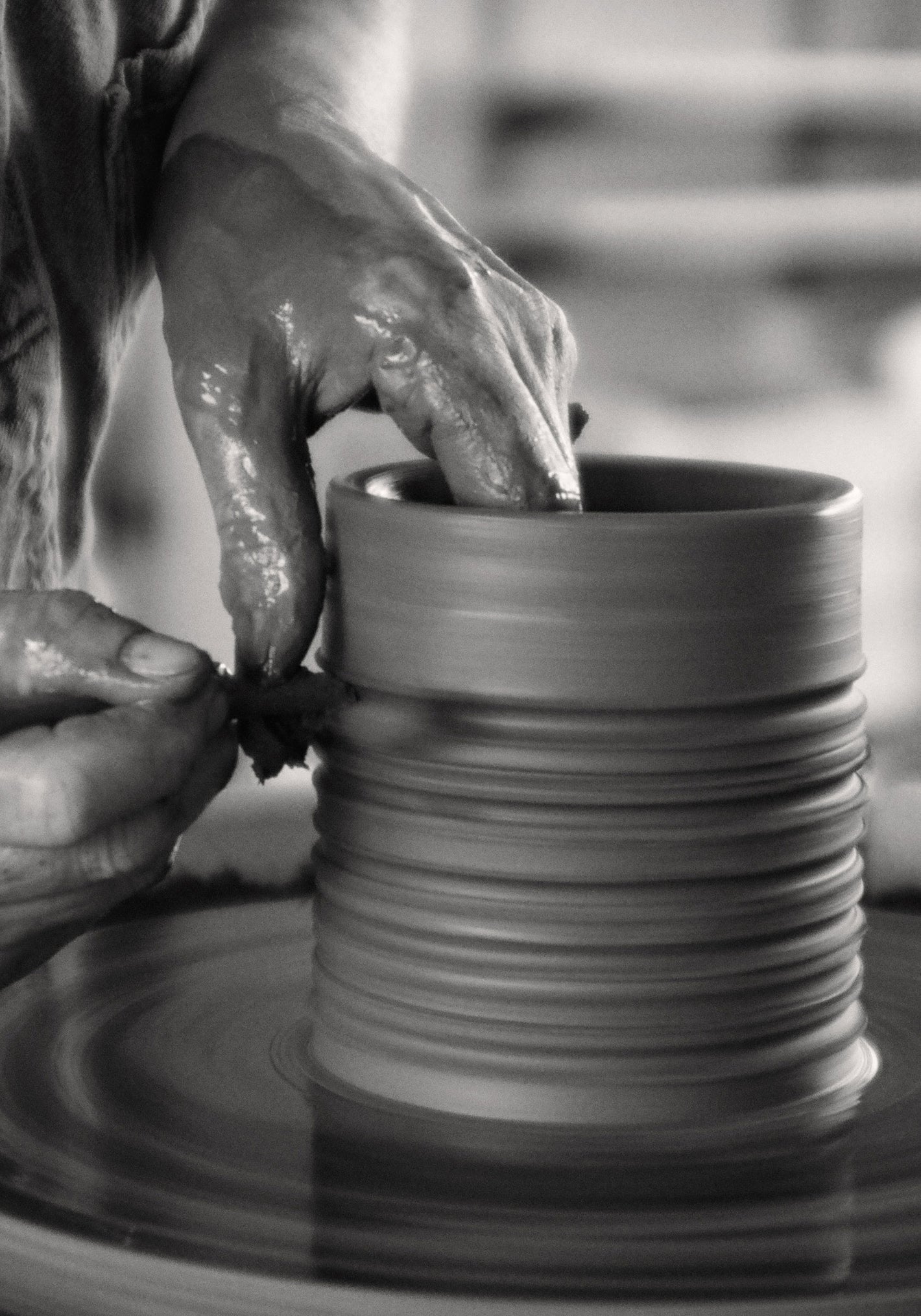 Potter shaping a ceramic vessel for the Diplomatico Scented Candle, highlighting handmade rough finish and carved lines, capturing the essence of Róhe's woody-aromatic fragrance.