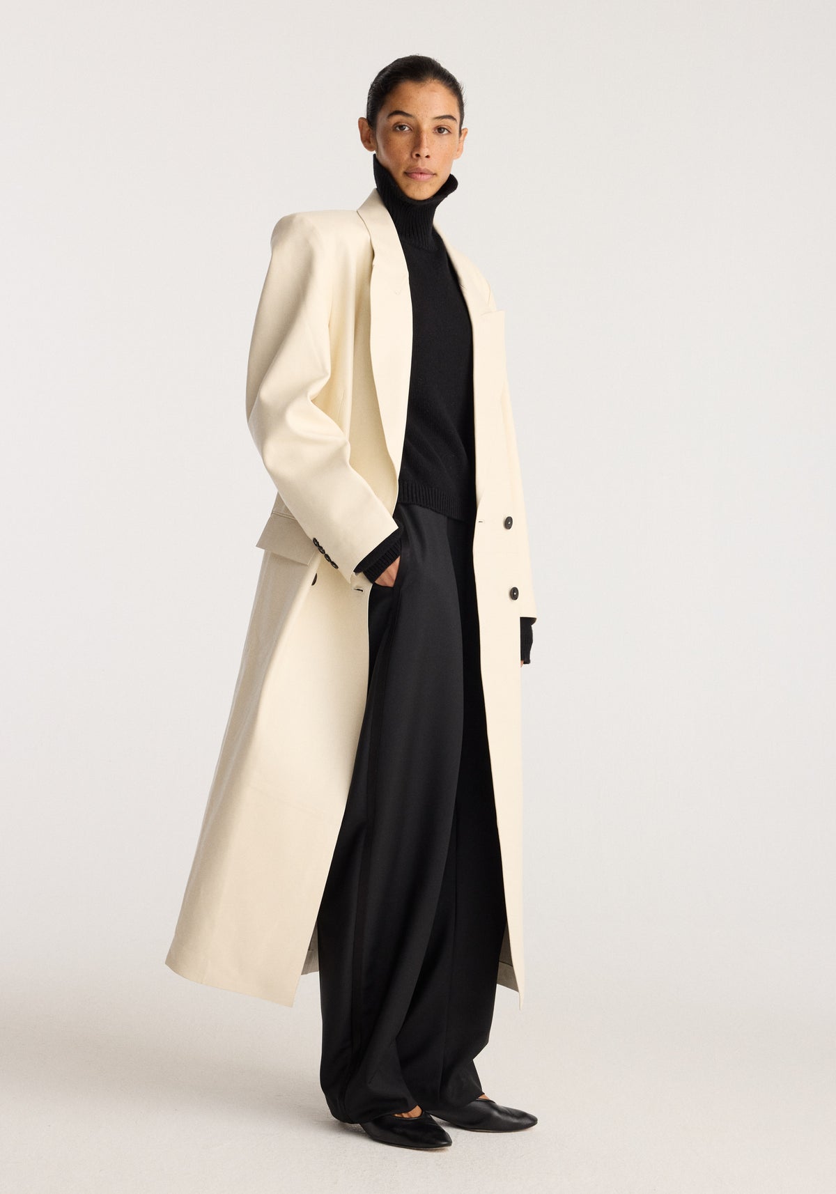 Menswear Inspired Bonded Leather Coat | chalk worn over a black turtleneck and wide leg trousers with a model standing in a studio
