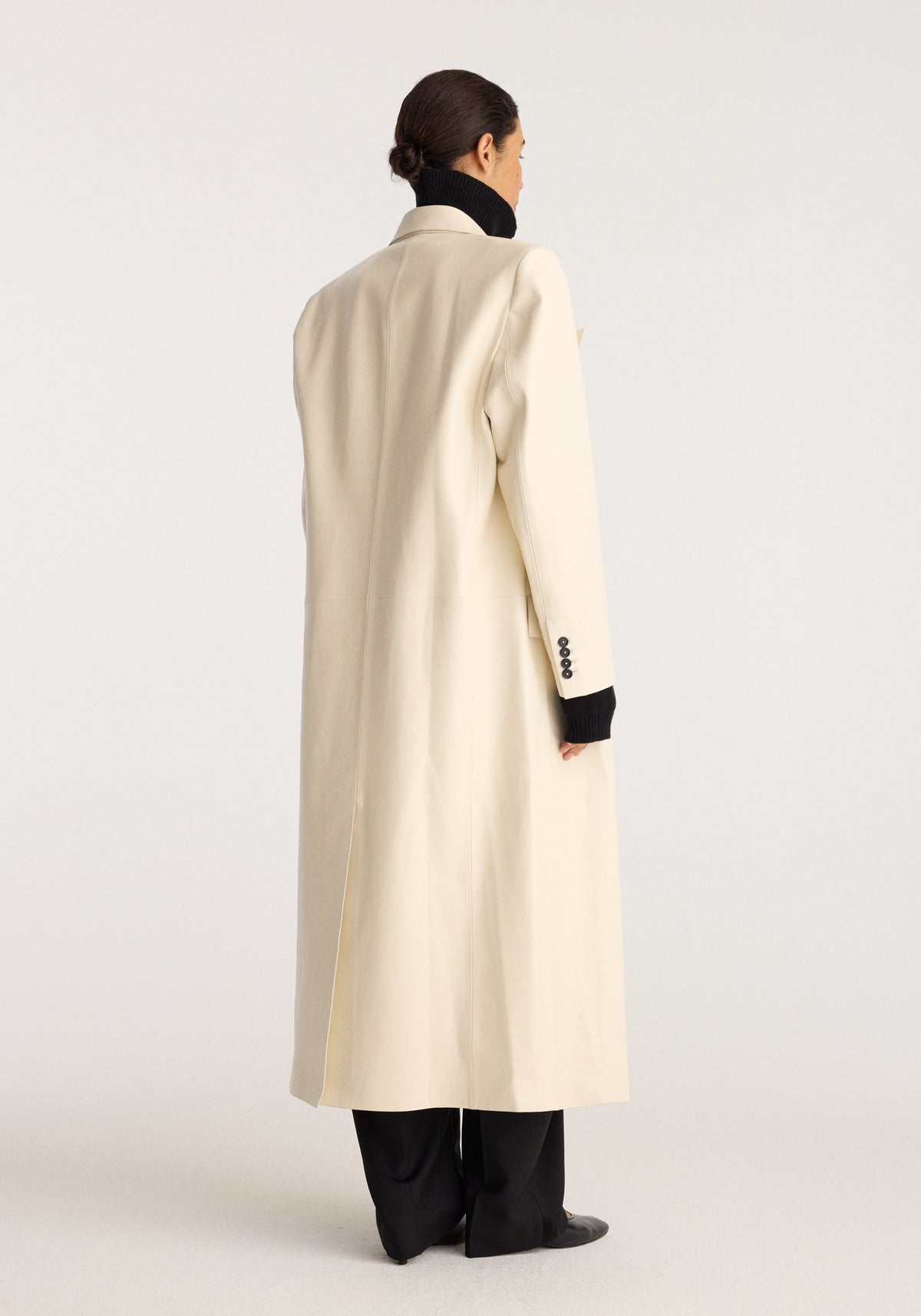 Menswear Inspired Bonded Leather Coat | chalk shown from the back on a model with a long light cream silhouette high collar and buttoned cuffs